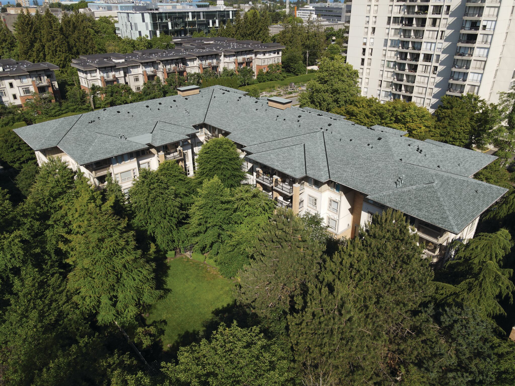 The Winslow Commons with an IKO roof, surrounded by pine trees.